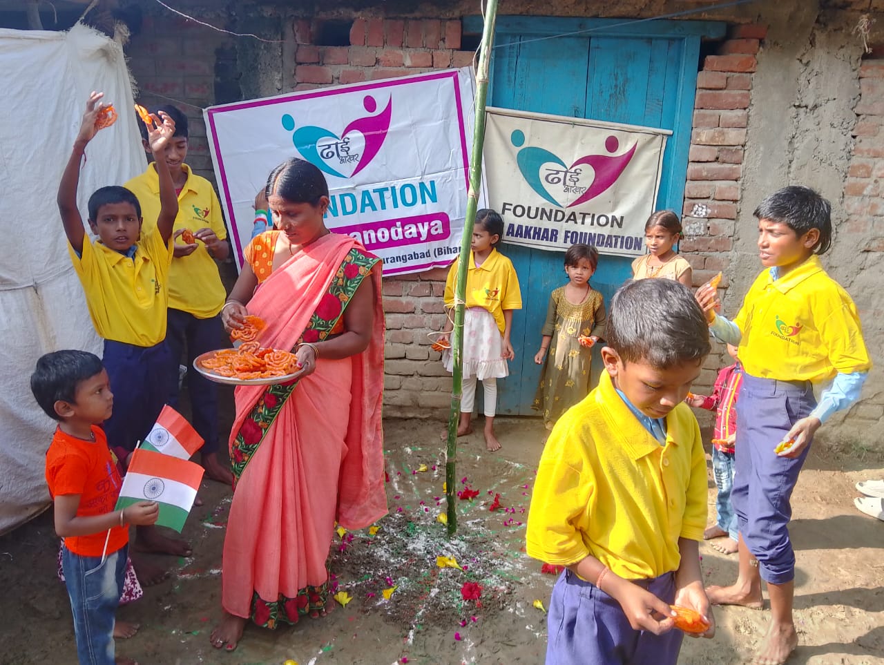 Smiling children in yellow uniforms with flags.